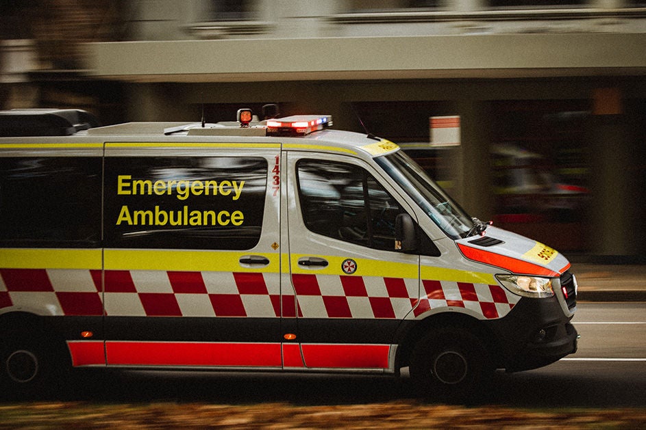 An emergency ambulance moving swiftly down a street, sirens blaring as it heads to assist in a medical situation.