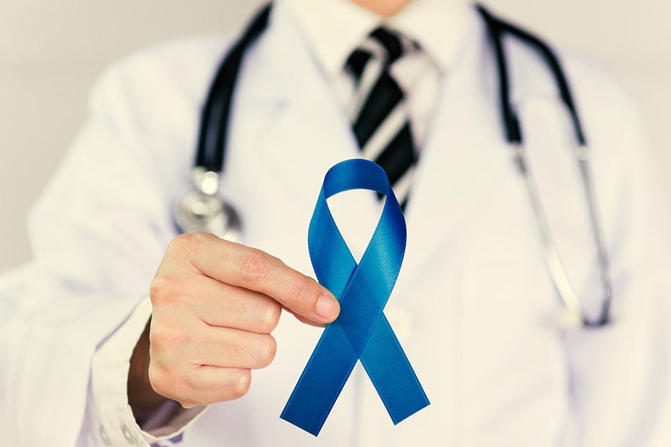 A doctor gestures towards a blue ribbon