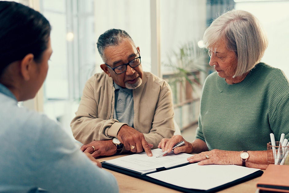 an old couple sitting together, with an expert helping them with their Wills