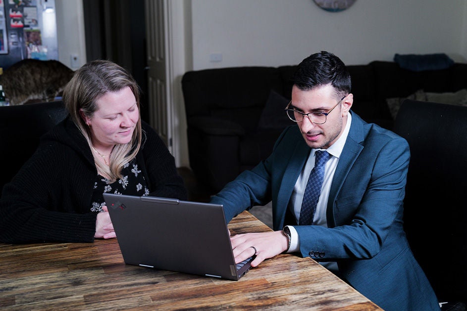 Maurice Blackburn lawyer Ross Sottile and client Rebecca sitting by the table, working through her case.
