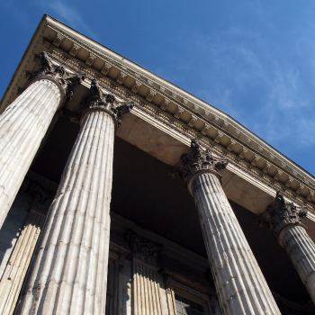 A worms-eye view of the pillars at the entrance to a court house