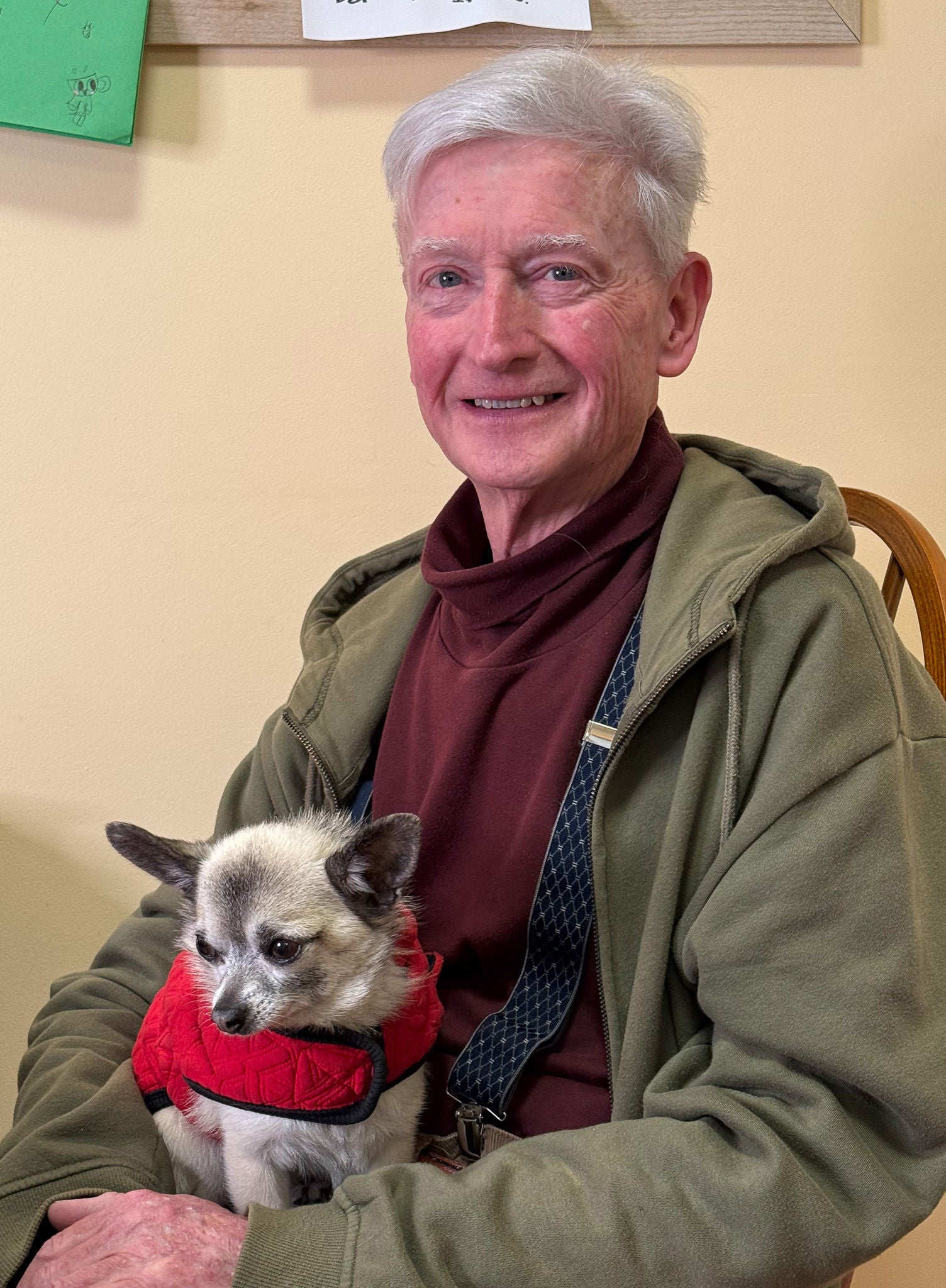 Maurice Blackburn client Tony sitting on a chair with his dog.