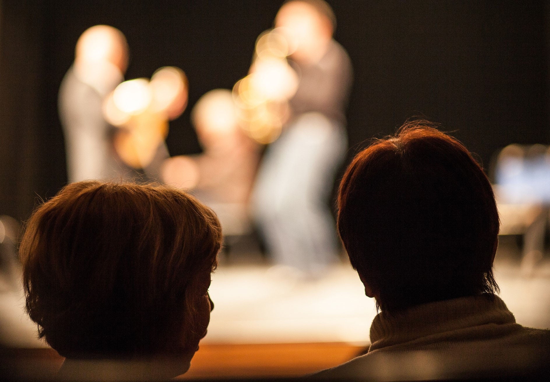 two people watch a stage show