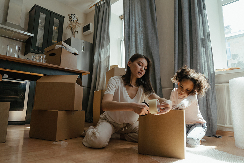 A woman and child packing boxes in their rental property