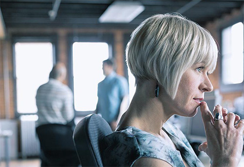 a respondent in a workplace complaint, a woman sit at her desk looking contemplative