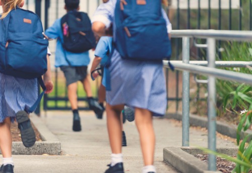 School children in school uniform running 