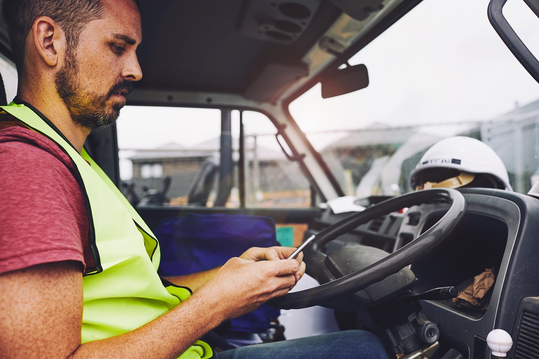 Driver texting on the phone inside a truck, disobeying QLD mobile phones laws