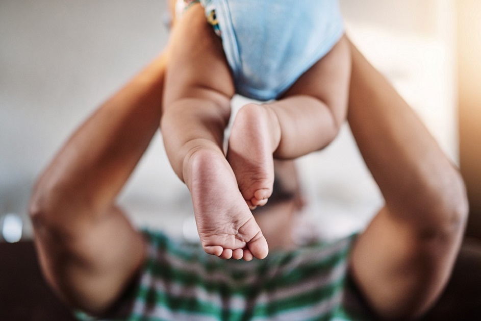 A dad holds up a baby