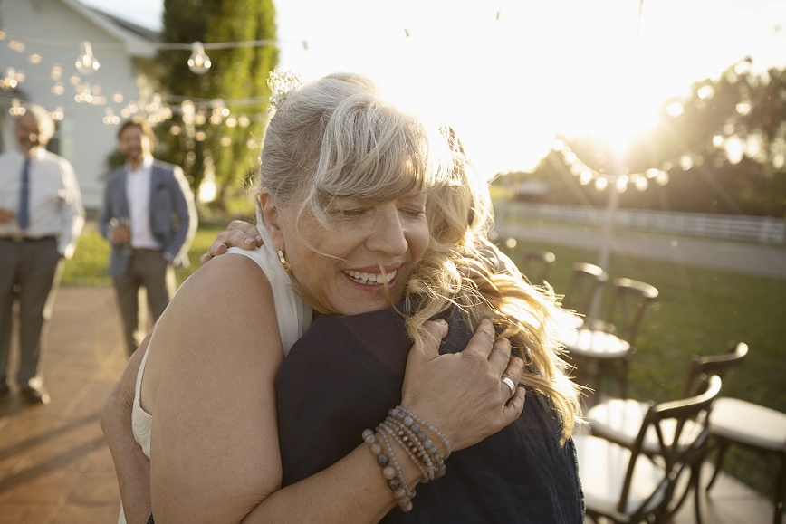 two women hugging at sunset