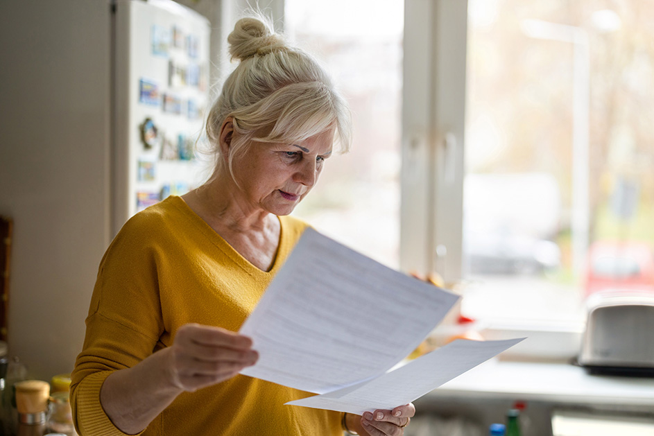 A women looking into document paper by the window.