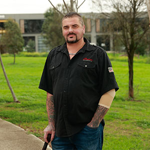 Maurice Blackburn client Andrew standing outdoors on a path, looking at the camera