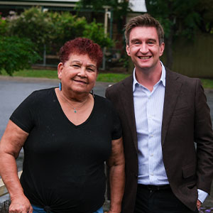 Maurice Blackburn client Angie and lawyer Ric standing side by side smiling.