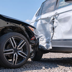 Close-up of two cars with significant collision damage after a side-impact road accident.