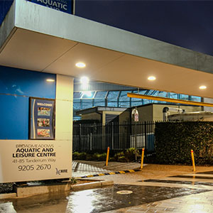 An aquatic and leisure center building at night.