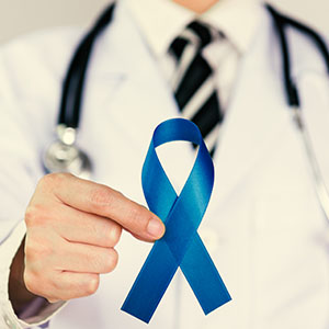 A doctor gestures towards a blue ribbon