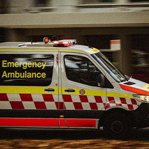 An emergency ambulance moving swiftly down a street, sirens blaring as it heads to assist in a medical situation.