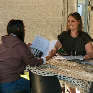 Maurice Blackburn lawyer Laura and her client Tracey sitting by a table reading through some documents together.