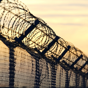 A chain link fence with razor wire at the top